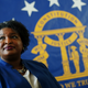 Democratic candidate for Georgia Governor Stacey Abrams poses for a portrait in front of the State Seal of Georgia Monday, Aug. 8, 2022, in Decatur, Ga.